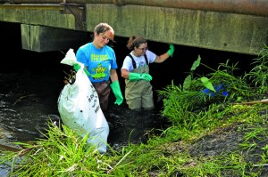 Annie Chambers (left) and Alicia Smith donned waders before entering McCoys Creek during the clean-up