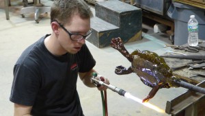 Brian Frus adds detail to a glass turtle for his sculpture.