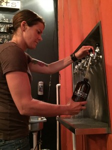 Kelly Pickard, owner of Alewife Craft Beer Bottle Shop and Tasting Room, fills a 32-ounce growler with beer.