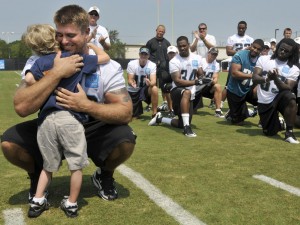 Jacksonville Jaguars center Brad Meester hugs Luke Akerstrom, 6, as players and coaches applaud after practice at NFL football training camp, Aug. 4, 2011. Meester and Luke became friends after Meester's visits to Wolfson Children's Hospital and Brooks Rehabilitation eight months after Luke began having seizures. 