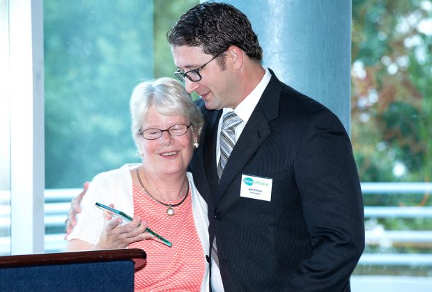 Susan Mattox presents Seth Williams, publisher of The Resident, with an award for his contribution of public awareness of Vision Is Priceless’s mission.