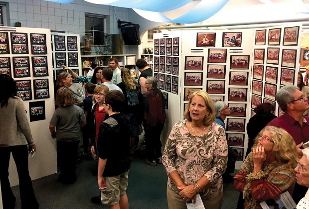 Guests at the Ruth N. Upson Elementary School 100th Anniversary tour a display of class photos through the years.