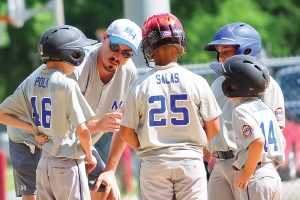 A coach gives tips to members of a Cal Ripken Baseball League team at Murray Hill Athletic Association park.