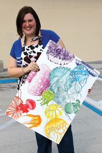 Meredith Sullivan with a small-scale sketch of her jellyfish mural for J&W Discount.