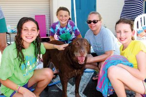 Shelby Robinson, Eleanor McArthur, Emily Garrett and Ellie Digesare give Dutch a bath to raise funds for the Jax Dog Café.