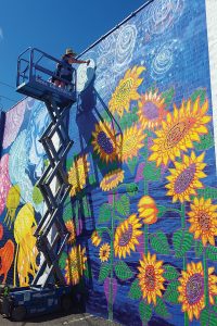 Brenda Kato puts the finishing touches on a 25-foot-tall mural a week before its July 8 unveiling.