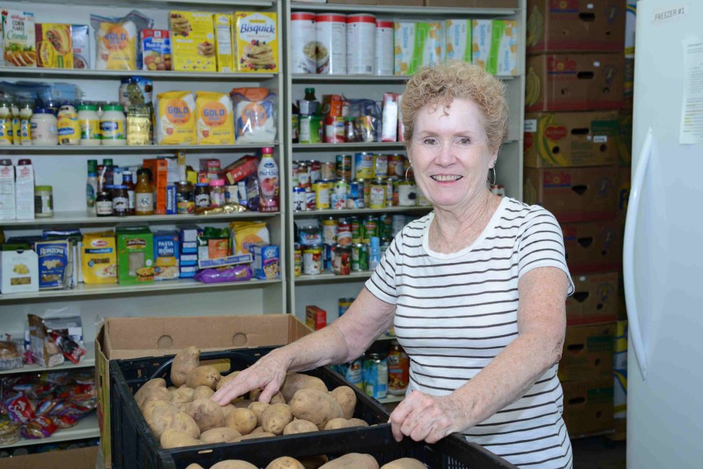 Eileen Smith serves in the food pantry, handing out food, greeting clients at Downtown Ecumenical Services Council.