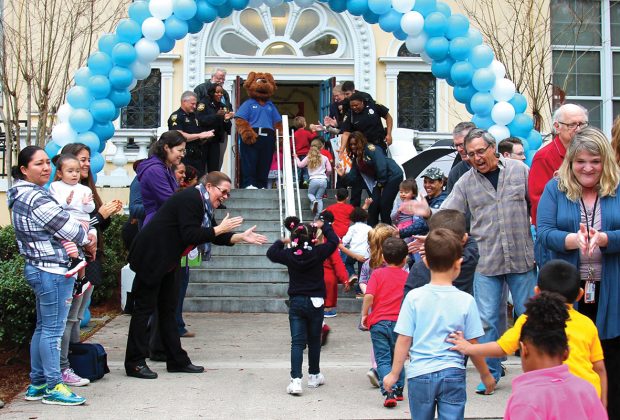 Parents, faculty and first responders greet West Riverside Elementary School students with “high fives” on the school’s second annual Kindness Day Feb. 14.