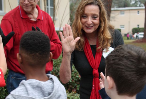 Amy Barnett, founder of the American Civility Association, give a “high five” to West Riverside Elementary School students.