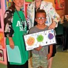 Lisa Bond, teacher of gifted students, with visual arts educator Terry Woodlief, who is wearing a jacket decorated by her students, and kindergartner Christopher Turner
