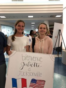 At the airport, Olivia Nolan, left, welcomes Juliette Vasseur to Jacksonville.