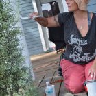 Hallie Dufresne paints a porch column during a renovation project for a home in Springfield.