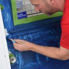 Michael McCall paints the front door during a renovation project for a home in Springfield.