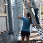 Sheryl and Eddie Dwyer paint siding during a renovation project for a home in Springfield.