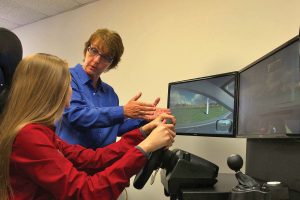 Trish Johnson gives a Wolfson student driving instruction on the Apex Virtual Vehicle©, a gift donated to the school by the Coker Law firm.