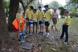 Prospective Eagle Scout Will Weinbecker demonstrates how to clean a gravestone in the Historic St. Nicholas Cemetery with Wet & Forget as his fellow Boy Scouts watch.