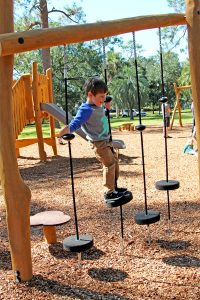 Sawyer Collins show off his balance skills at the new playground in Four Corners Park in Murray Hill.