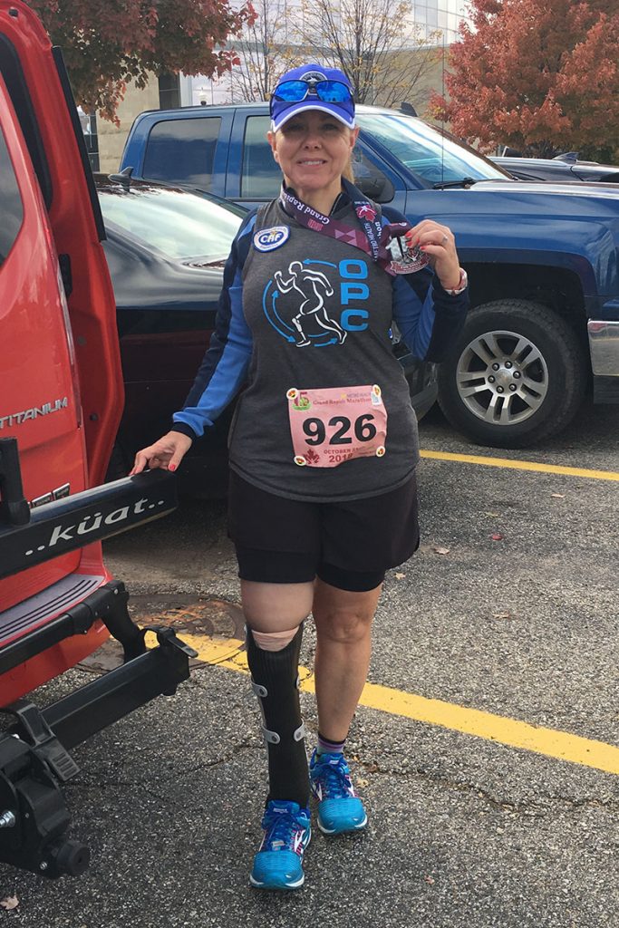 Kelly Luckett displays her finisher’s medal at the Grand Rapids Marathon.
