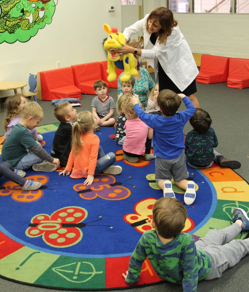 Dr. Jila Mahajan squirts preschool students with water after teaching the class about the importance of oral hygiene.