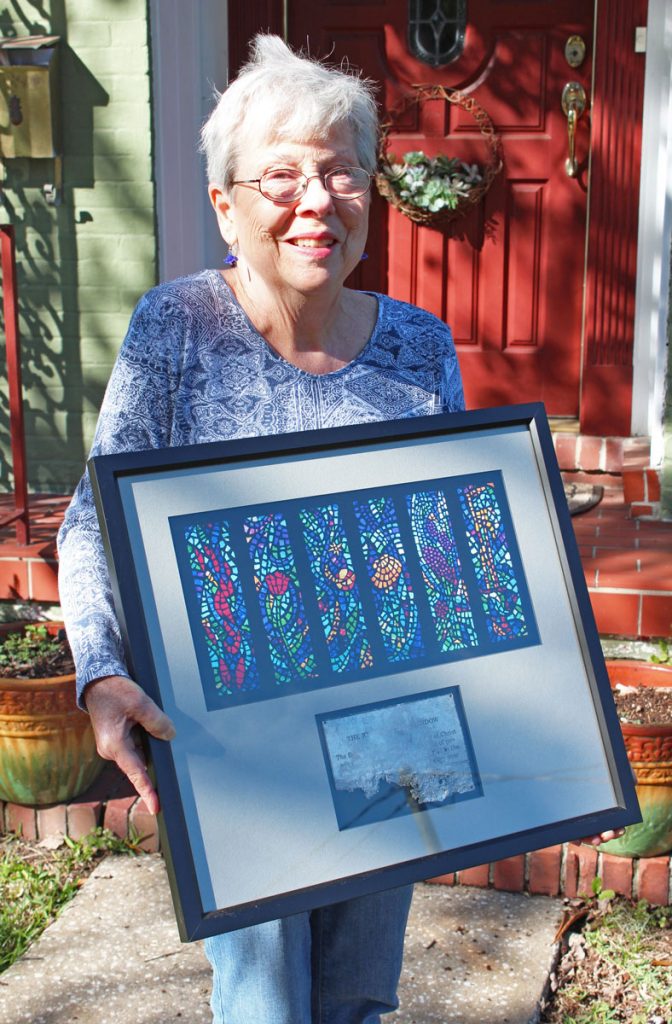 Joyce Hanson holds the Resurrection Plaque, depicting stained-glass windows donated in her father’s memory in 1972, resurrected from the Hendricks Avenue Baptist church fire in 2007.