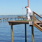 Annie Pajcic tees off at the infamous hole-in-one challenge from a dock at Steve Pajcic’s Avondale home.
