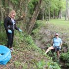 Julie Hatcher, left, with her sister, Jeanine Harding, clean up Azalea Creek, a small waterway they played in as children. This is the first year they have participated in the St. John River Cleanup and said they found a metal pipe, a sock, baseball cap and ball, glass bottles and soda cans, wire, and a lot of plastic bags in the creek.