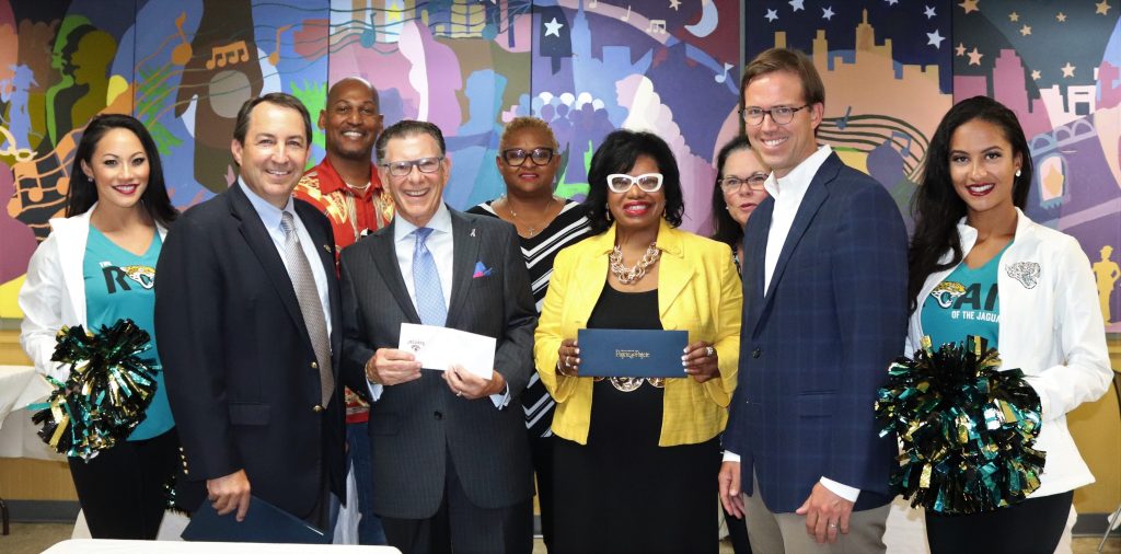 Flanked by members of the Jaguars ROAR are Chris Sutton, Joe Whitaker, Ju’Coby Pittman and Michael Pajcic. In back: Thomas Waters, Diana Mason, and Dee Paez, board members.