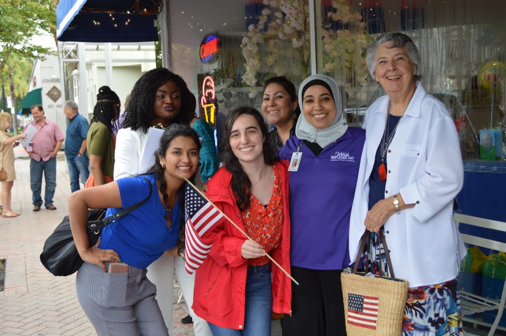 Lutheran Social Services Volunteer Greta Apilstoli (in red), World Refugee Day Committee Member Hind Chalio (in purple) and Elaine Carson, better known as “Mrs. P,” founder of World Relief in Jacksonville, stand with some newly minted American citizens after a naturalization ceremony at Theatre Jacksonville in San Marco June 13.