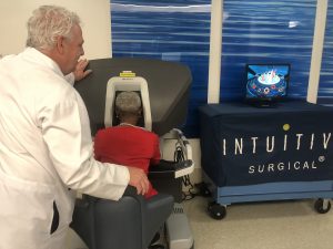 Dr. Stephen Buckley watches as his former patient, Delaney Williams, tests out the da Vinci® Surgical System.