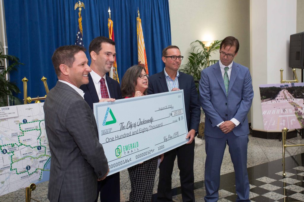 David Miller, Brightway Insurance; Brian Wolfburg, VyStar Credit Union; Kay Ehas, GWJax; and Michael Pajcic, Pajcic & Pajcic (far right) present a ceremonial check to Mayor Lenny Curry (second from right) for $180,000, GWJax's portion of the first 1.3-mile Model Project design costs for Emerald Trail.