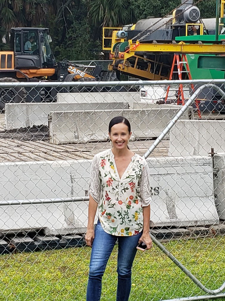 Michelle Wright, president of the Millers Creek Special Tax District, stands in front of the de-watering equipment used by DredgIt, the contractor Millers Creek residents have hired to dredge the creek.