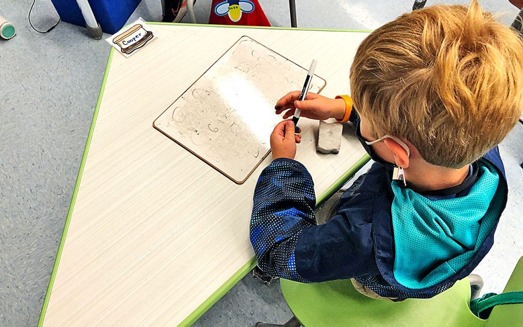 A first grader works at his desk at John Stockton Elementary