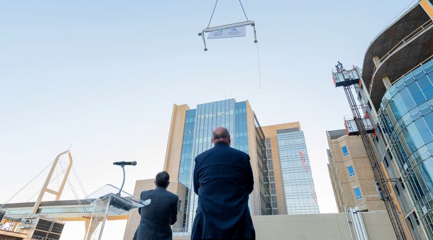 Longtime plans come together as final beam rises to rest atop new critical care tower