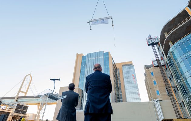 Longtime plans come together as final beam rises to rest atop new critical care tower