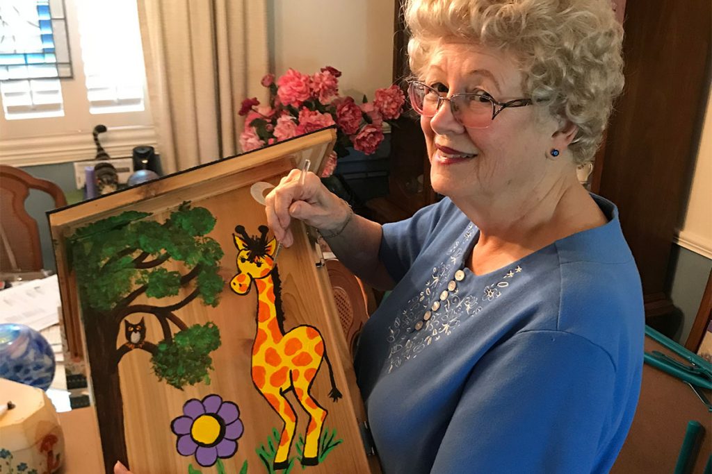 Julie Babcock painting a Little Free Library, 2020