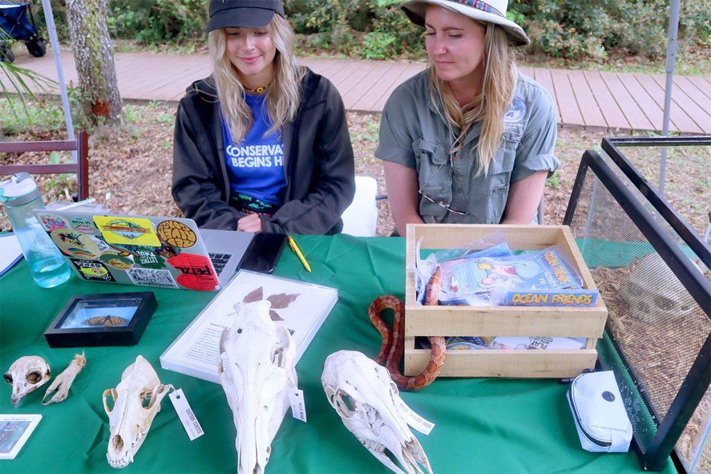 Jacksonville Parks Naturalist Jolie Friedrich & intern Camryn Middlebrooks with non-venomous corn or red rat snake at 7 Creeks Festival.
