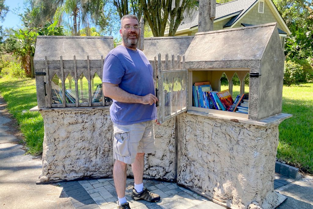 Chris Atchison stands in front of the tiny library