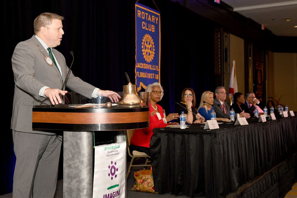 Bill Sorenson, past president, Rotary Club of Jacksonville, led the meeting and delivered the opening remarks for the first Mayoral debate of the 2022-23 election season. Seated to his right were the slate of the seven participating candidates.