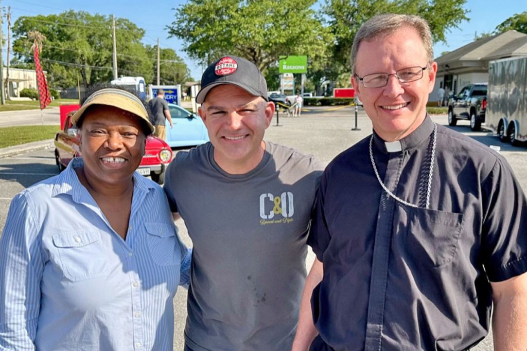 San Jose Car and Truck Show officials Alma Ballard and Chris Brewer with Bishop Erik Pohlmeier of the Diocese of St. Augustine