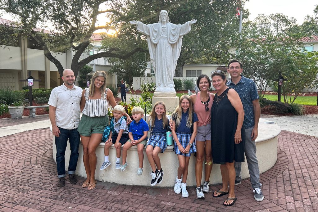 A multi-generational first-day family picture in Assumption Catholic School’s courtyard, including alumni grandmother and mothers, as well as four attending cousins, spanning Class of 1970 to Class of 2034.
