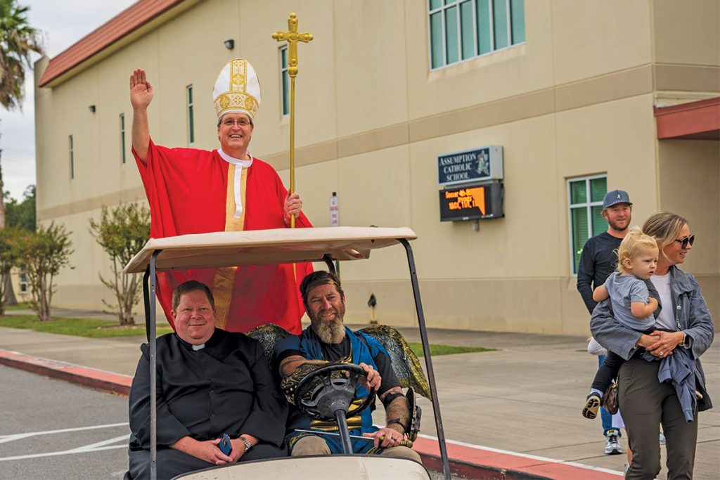 Father Jason, along with Bruce Eaker, toted Deacon Dale in the “Pope Mobile.”
