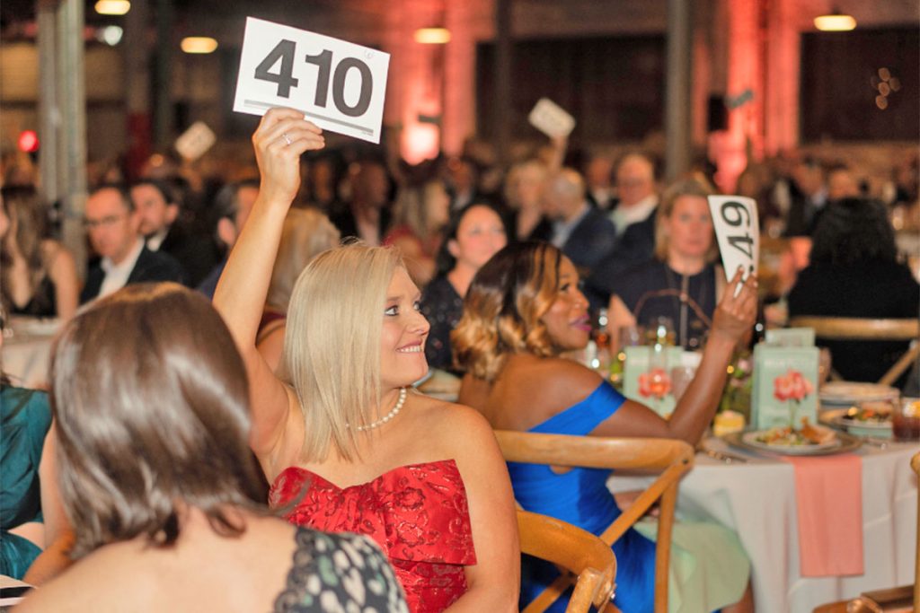 Katie Garner from Heritage Capital Group competes for a winning auction big to support survivors of human trafficking at Rethreaded’s annual Mukti Freedom Gala.