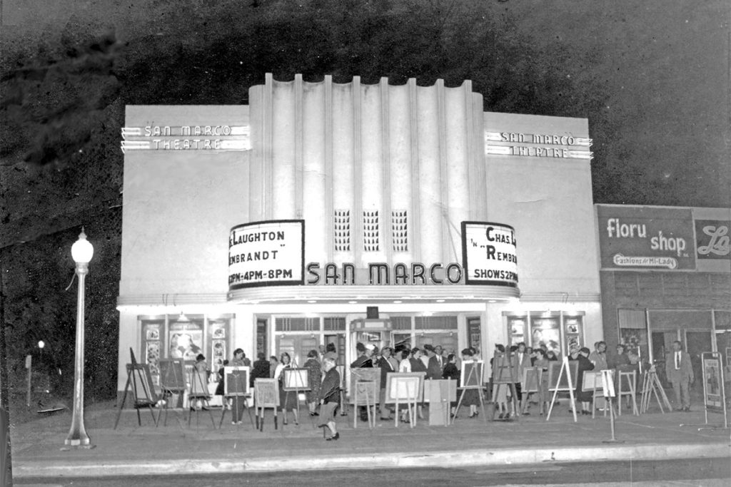 A historic photo of the San Marco Theatre lit at night.