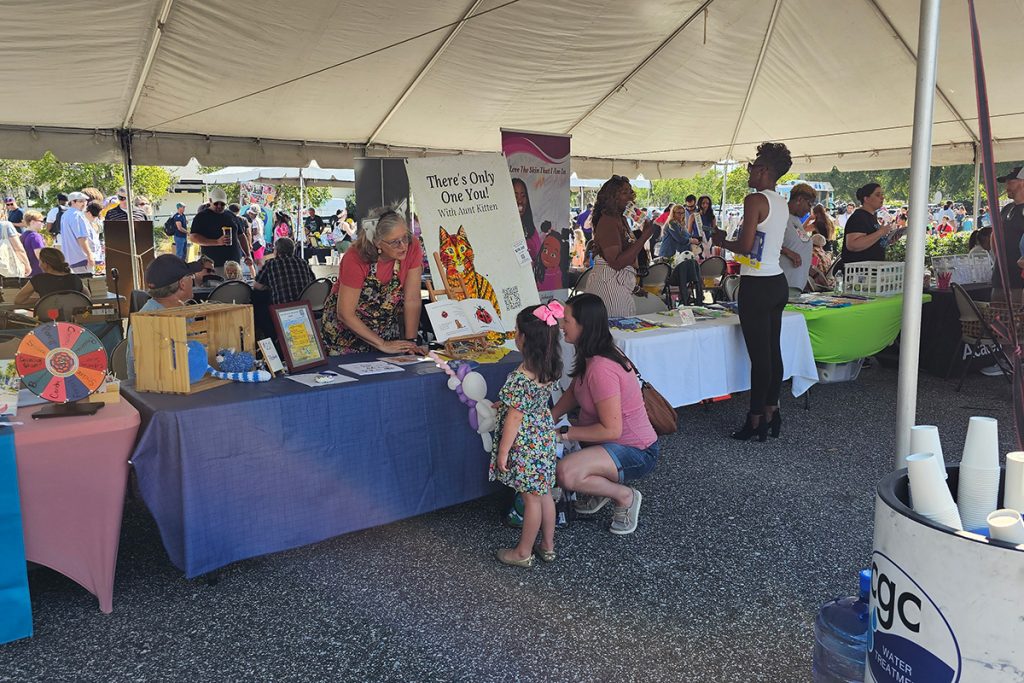 Families chat with local authors at the River City Readers summer kick-off event.