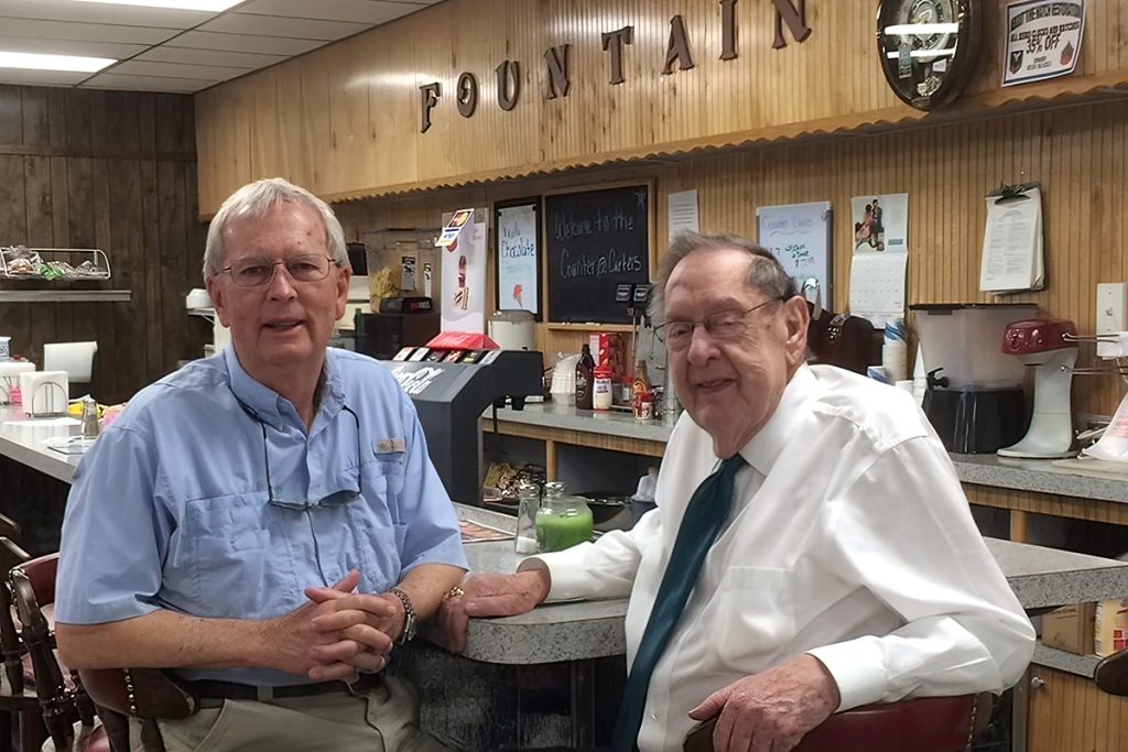 George Martin with Bill Carter at the counter of Carter’s Ortega Pharmacy.