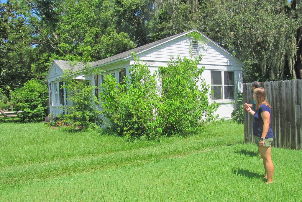 Ridgewood resident Rachel Brown stands in her front yard and points to the house next door, which has been purchased by developer SHEEPCO. Brown fears the developer plans to demolish the home as an access road for a new development of more than three dozen homes.
