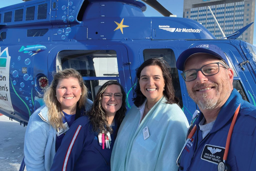 Ashley Helmick, executive director of the Women’s Board with Kids Care Mobile ICU Team Member Cortni Sant CCT RN, Kendra McCrary, president of the Women’s Board and Craig Skirvin CCT RRT in front of the Kids Kare helicopter. The Women’s Board of Wolfson Children’s Hospital is currently raising funds for this critical transport system.