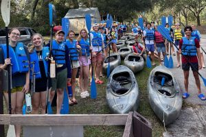 photo of students smiling and preparing to go kayaking