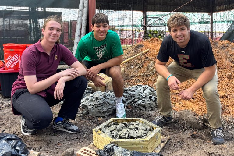 Foster Thompson, Liam Gonzalez and Sean Wolff pose with a Pervious Oyster Shell Habitat (POSH).