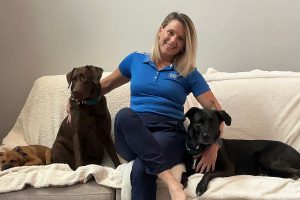 Dee Reibach with black lab Grace, chocolate lab Hope and new rescue lab-mix puppy Charlee